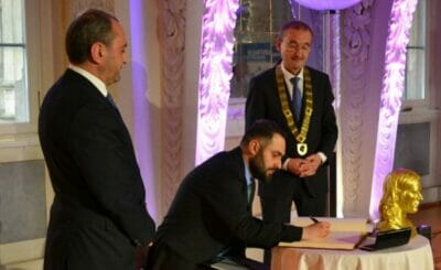 Preisträger Shashikyan trägt sich ins Goldene Buch der Stadt ein.