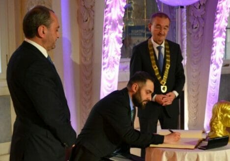 Preisträger Shashikyan trägt sich ins Goldene Buch der Stadt ein.